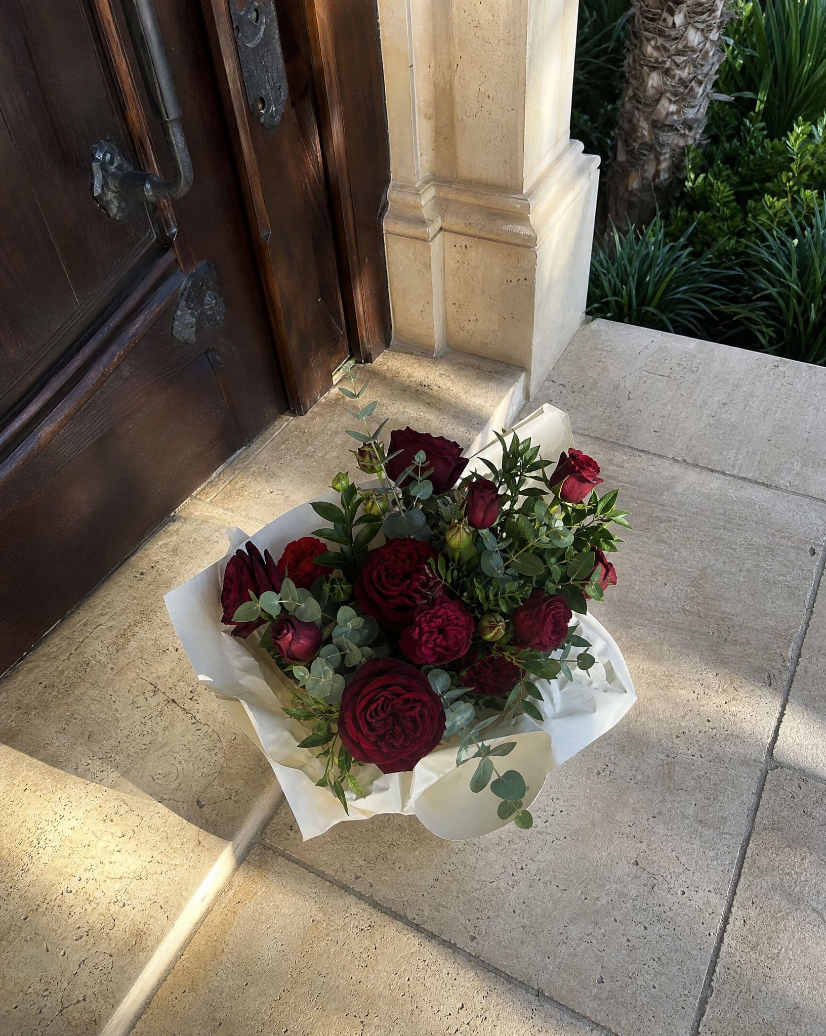 A bouquet of red roses at a front door